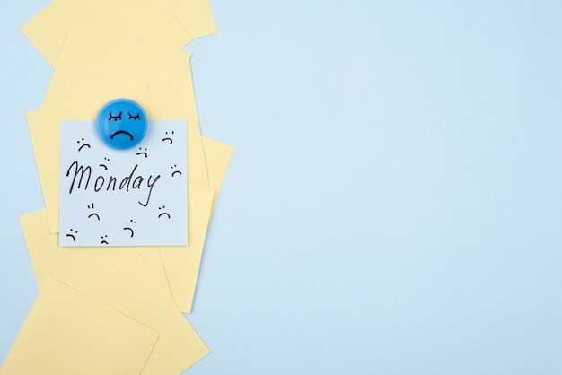 Free photo flat lay of sad face with sticky note and copy space for blue monday
