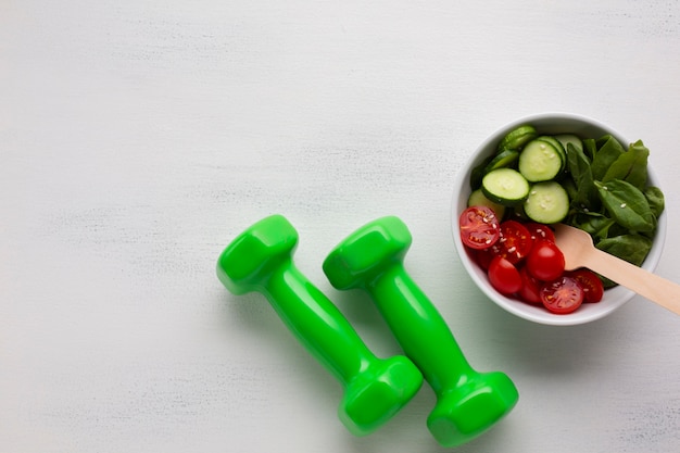 Flat lay of salad and weights