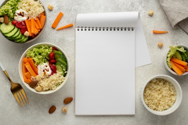 Flat lay salad with couscous and blank notepad