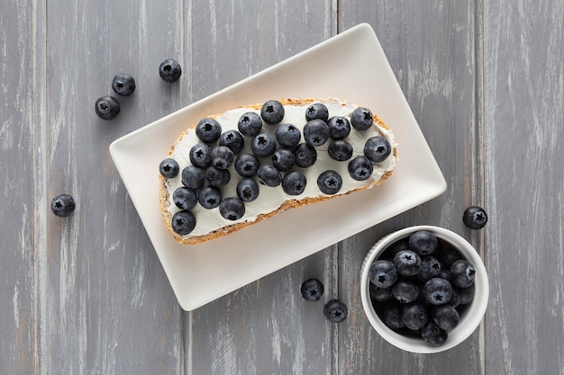 Flat lay sandwich with cream cheese and blueberries on plate