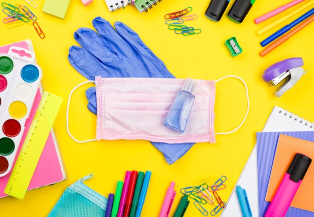 Flat lay of school essentials with gloves and pencils