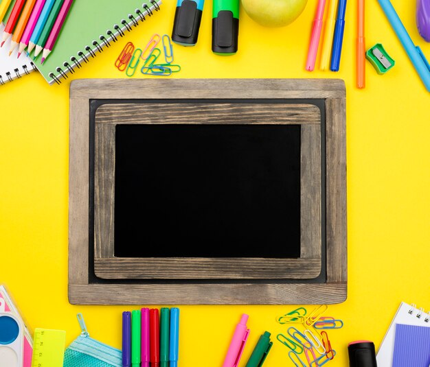 Flat lay of school essentials with pencils and blackboard