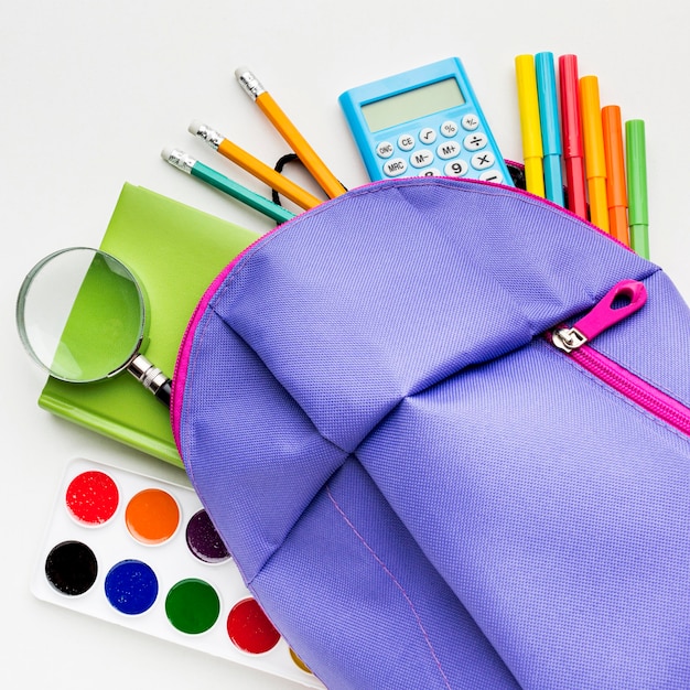 Free photo flat lay of school essentials with watercolor and backpack