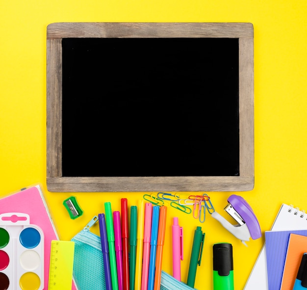 Flat lay of school essentials with watercolor and blackboard