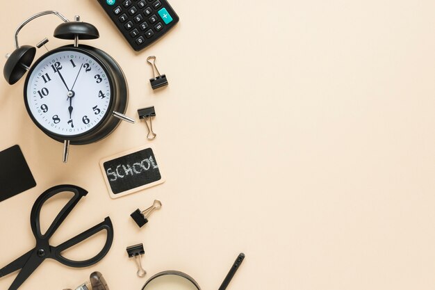 Flat lay of school supplies and alarm clock