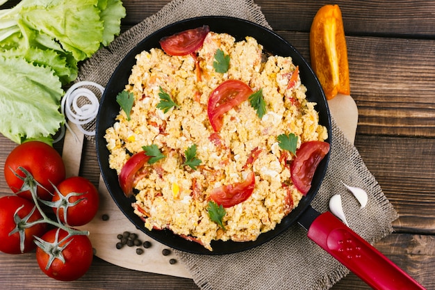 Flat lay scrambled eggs with tomatoes