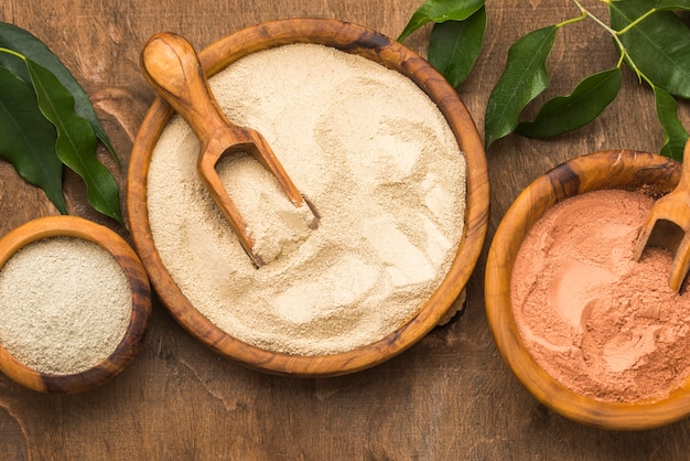 Flat lay of selection of fine powders in bowls with scoops