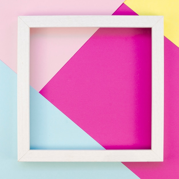Flat lay of simple frame with colorful paper geometry