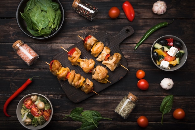 Free photo flat lay skewers on cutting board and ingredients