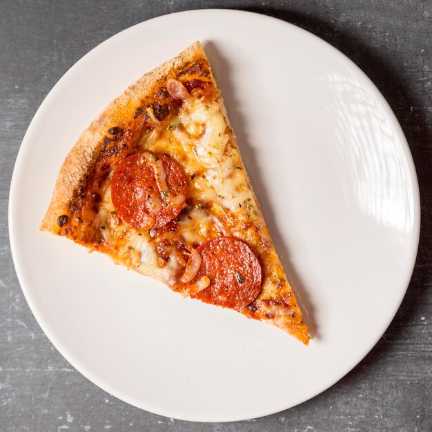Flat lay slice of pepperoni pizza on plate