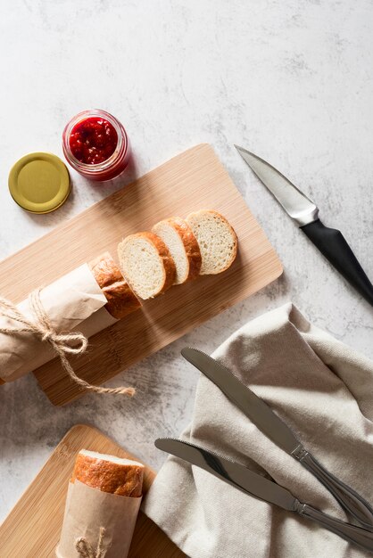 Flat lay sliced baguette with jam and honey