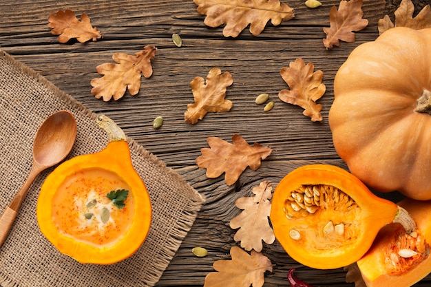 Flat lay sliced pumpkin and wooden spoon with leaves