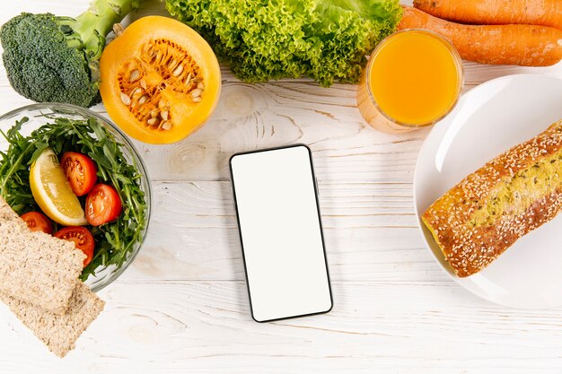 Flat lay of smartphone with meal and bread