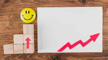 Free photo flat lay of smiley face and growth arrow