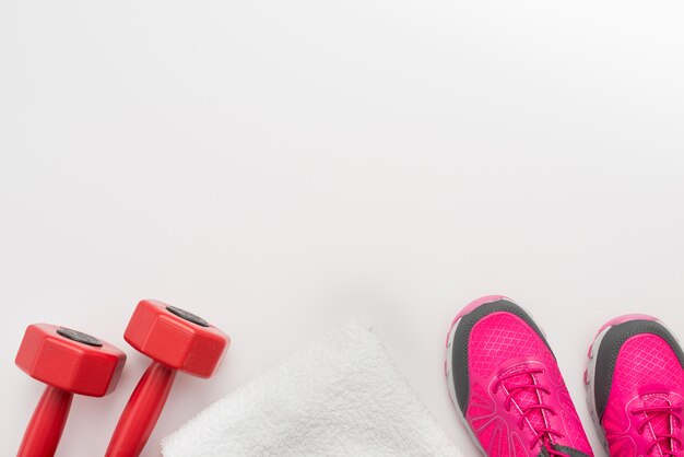 Flat lay of sneakers with towel and weights