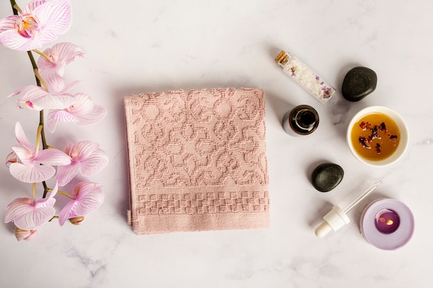 Free photo flat lay spa items with towel and flowers