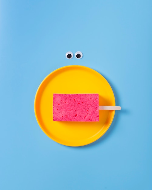 Free photo flat lay of sponge on plate on blue background