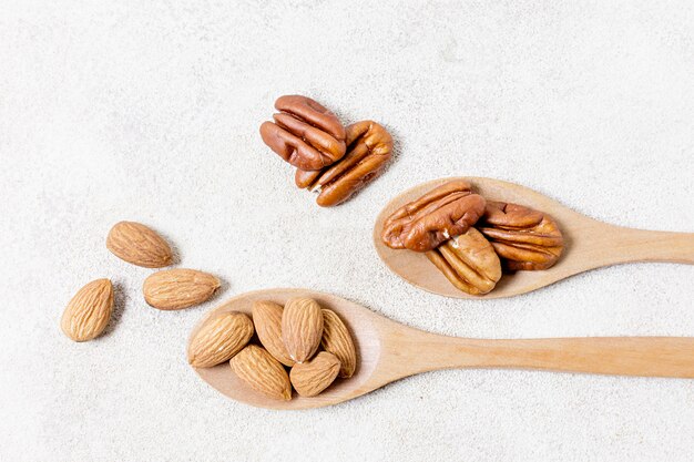 Flat lay of spoons with walnuts and almonds