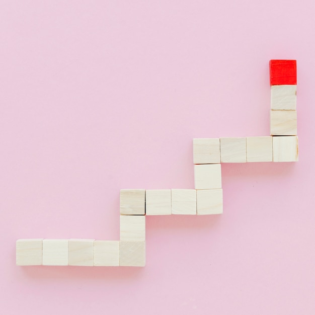 Free photo flat lay of stairs with wooden block and red mark