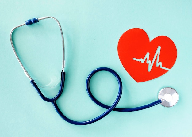 Flat lay of stethoscope with paper heart