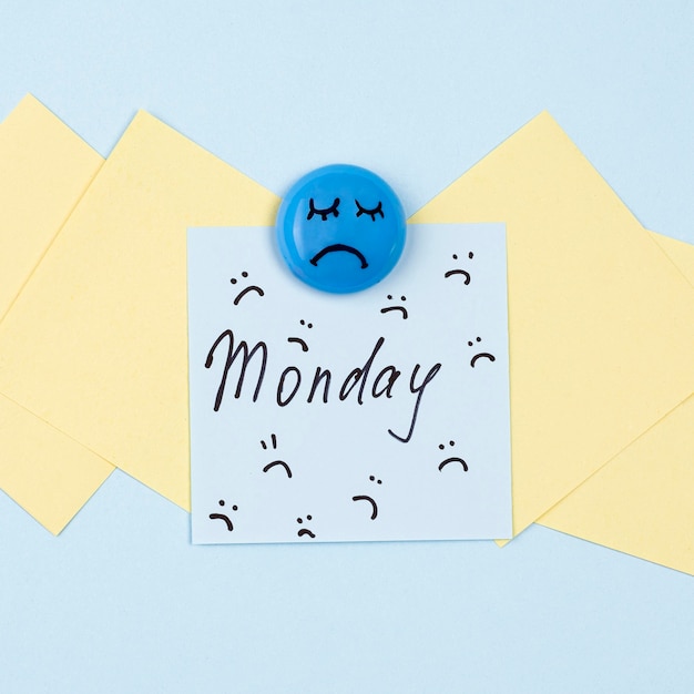 Free photo flat lay of sticky note with frowns and sad face for blue monday