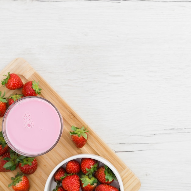 Flat lay of strawberry smoothie with fruits