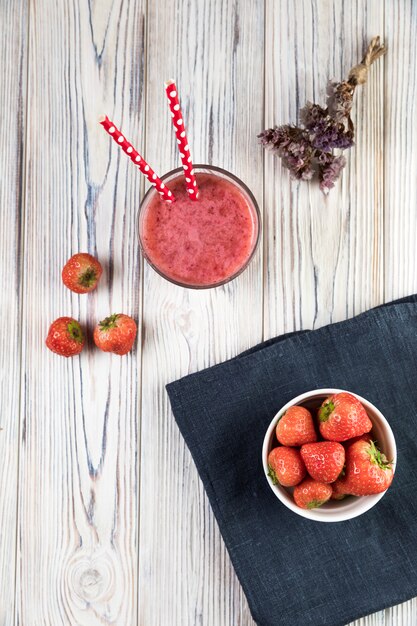 Flat lay strawberry smoothie on wooden table
