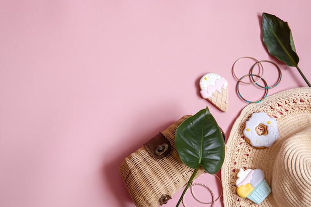 Flat lay summer composition with female accessories on pink background copy space.