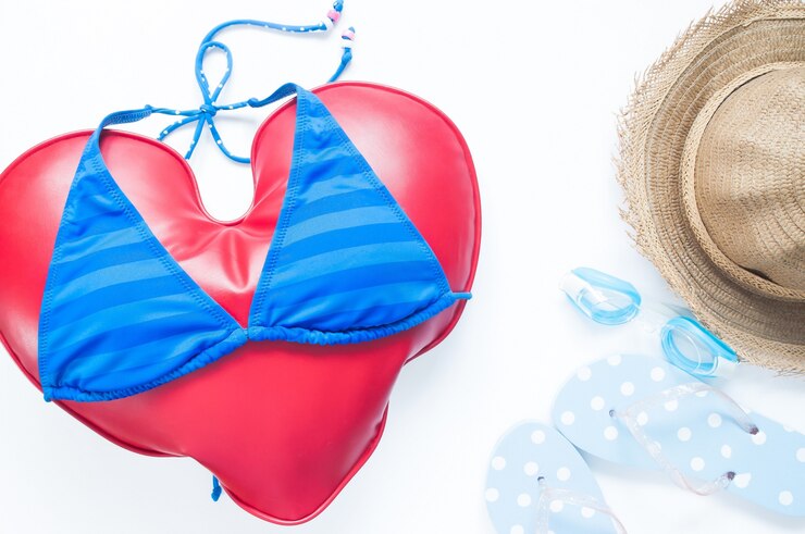 Free Photo flat lay of summer travel concept with heart wears bikini with goggles and sandals on white background, flat lay love vacation