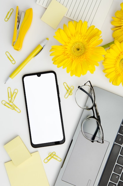 Flat lay supplies arrangement on desk with phone