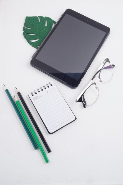 Foto gratuita flat lay di tablet ed elementi di office