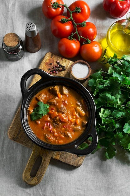 Flat lay tasty goulash and tomatoes