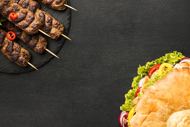 Flat lay of tasty kebab on slate with copy space