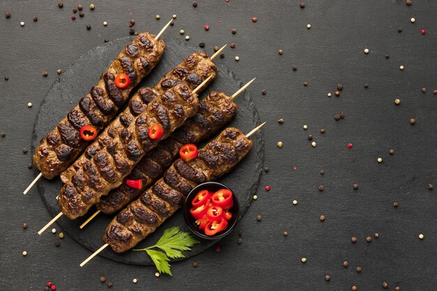 Flat lay of tasty kebab with condiments on plate