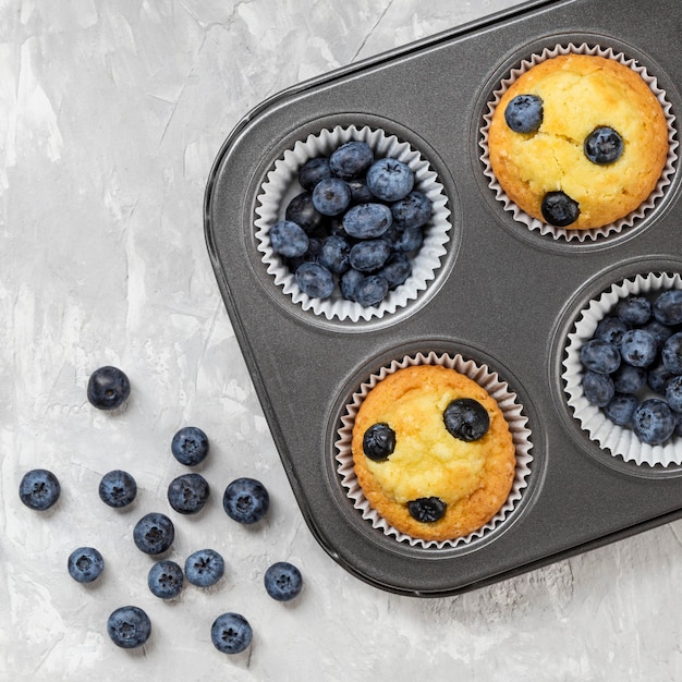 Foto gratuita muffin gustoso piatto con mirtilli frutti di bosco