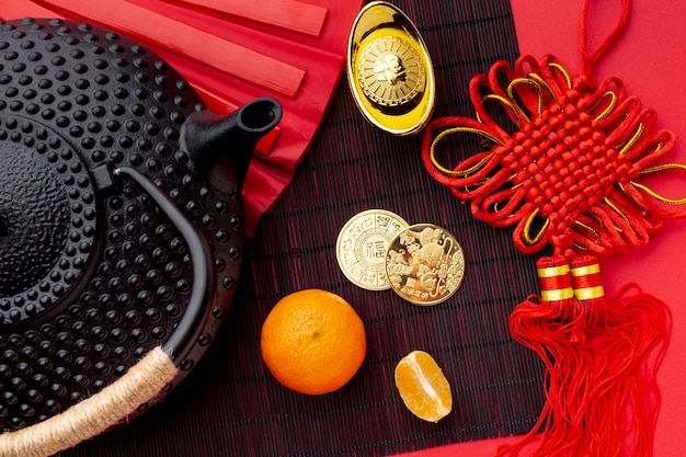 Flat lay of teapot and golden coins chinese new year