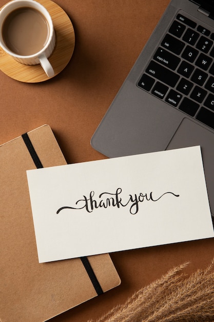 Flat lay thank you note and laptop