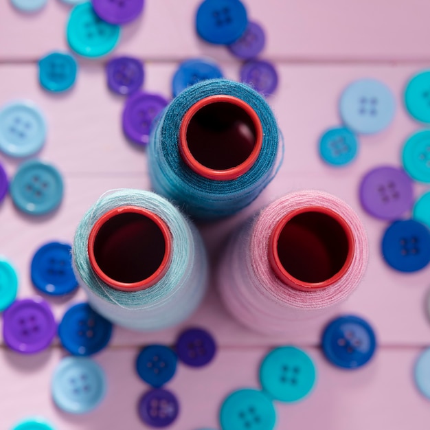 Flat lay of thread reels with blue buttons