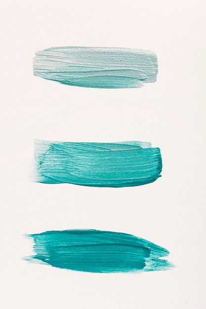 Flat lay of three blue paint brush strokes