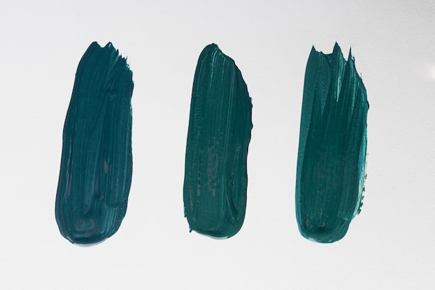 Flat lay of three creative blue paint brush strokes on surface