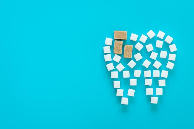 Free photo flat lay tooth made of sugar on a blue background