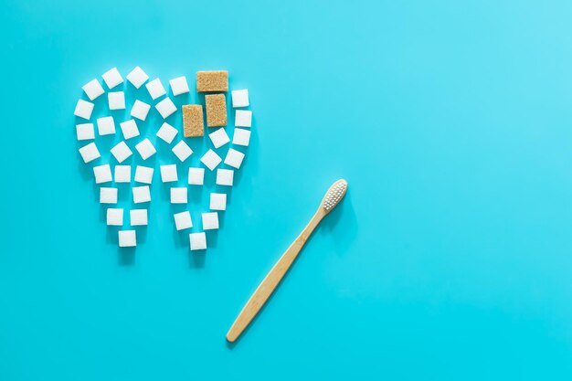 Flat lay tooth made of sugar on a blue background