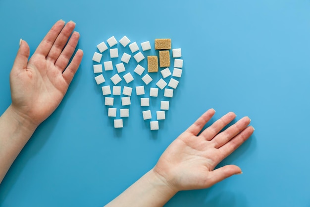 Free photo flat lay tooth made of sugar on a blue background