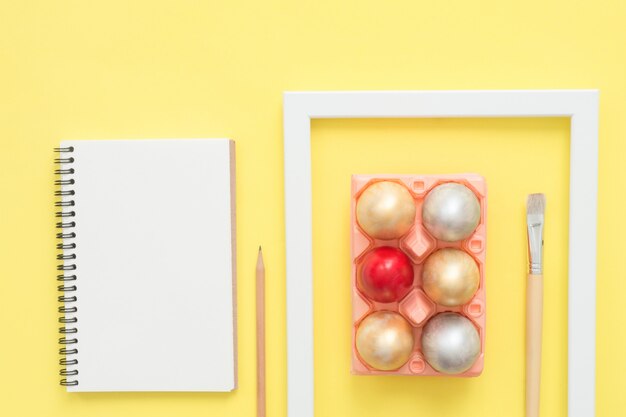 Flat lay top view colorful easter egg painted in pastel colors composition and mock up blank notebook