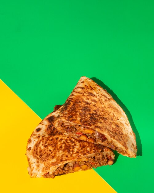 Flat lay tortilla crispy bread on green and yellow background