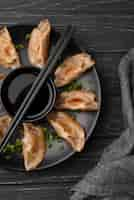 Free photo flat lay of traditional asian dish with chopsticks and dumplings