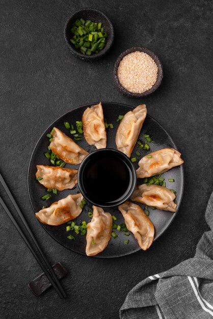 Flat lay of traditional asian dumplings with herbs and chopsticks