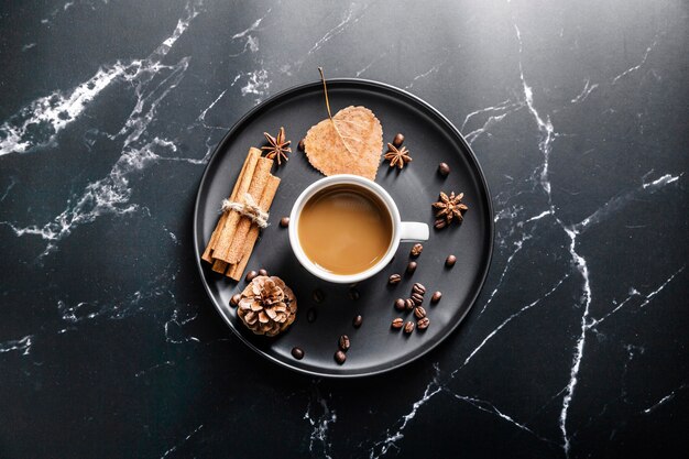 Flat lay of tray with coffee cup and cinnamon sticks