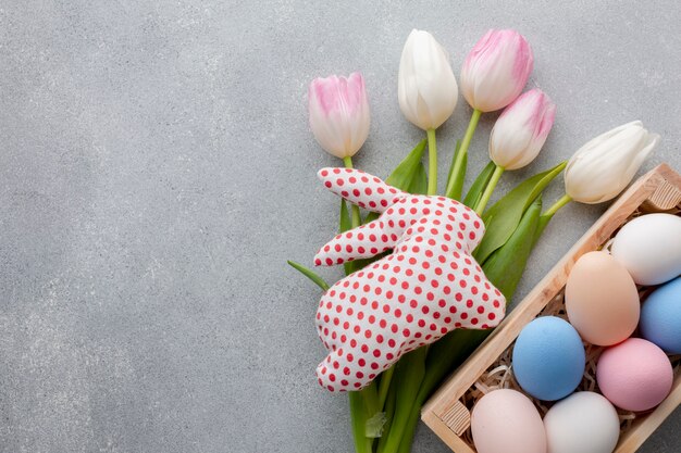 Flat lay of tulips and colorful easter eggs in box