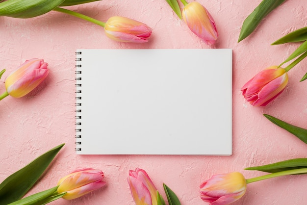 Flat lay tulips frame with notebook